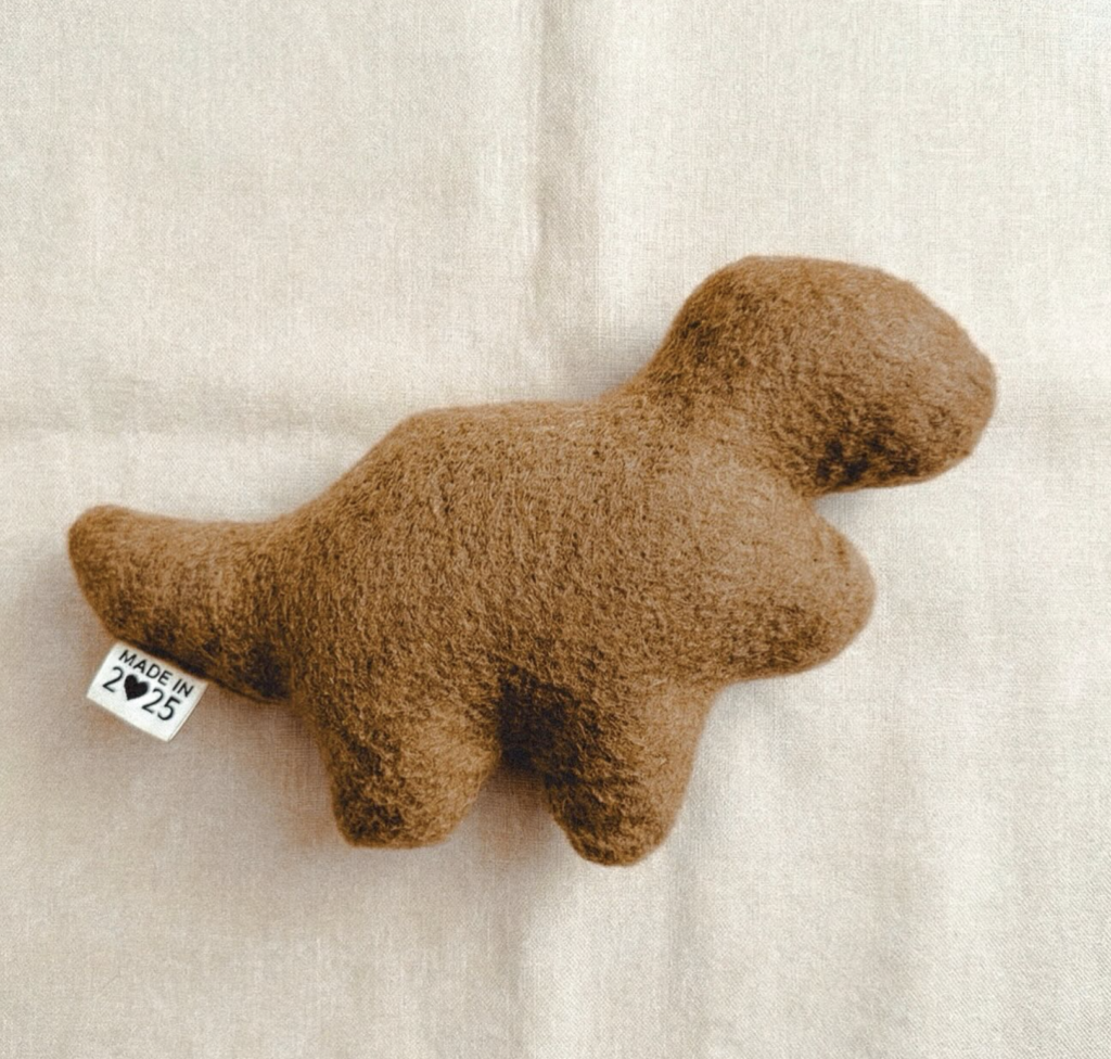 a simple stuffed figure in the shape of a dinosaur-shaped chicken nugget