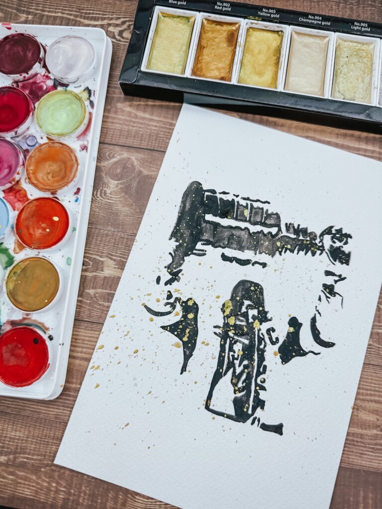 watercolor and ink painting featuring black brushstrokes and splatters on white paper with gold metallic accents, abstract gestural marks creating a sense of movement and layering